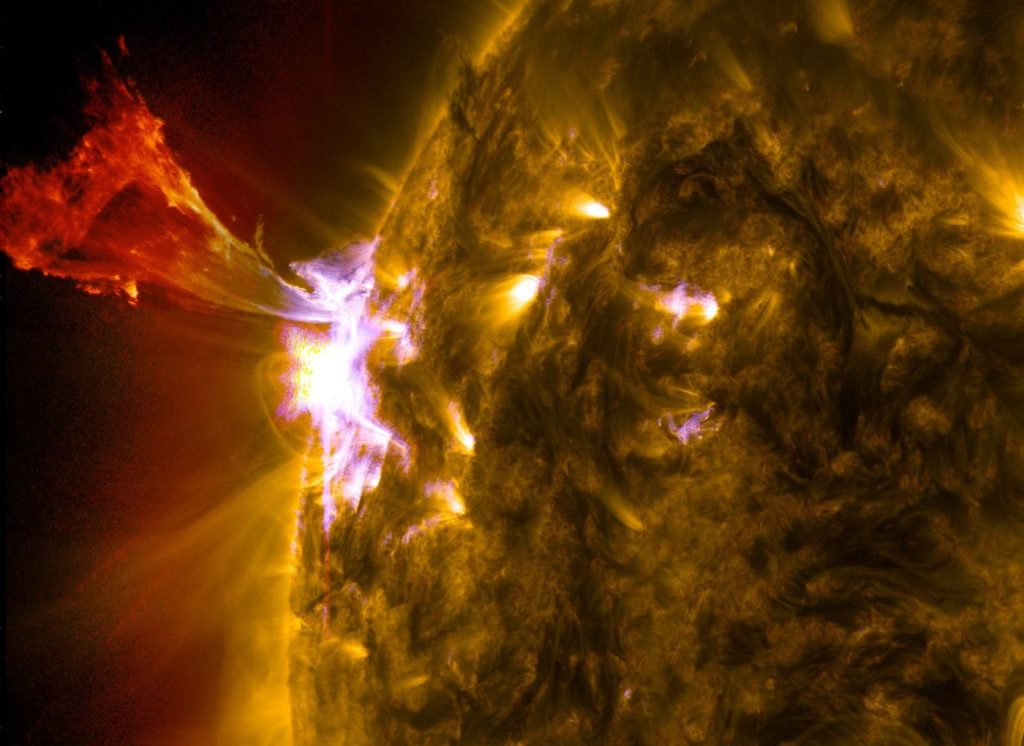 The sun erupting with a bright solar flare, captured by a space telescope against the darkness of space.
